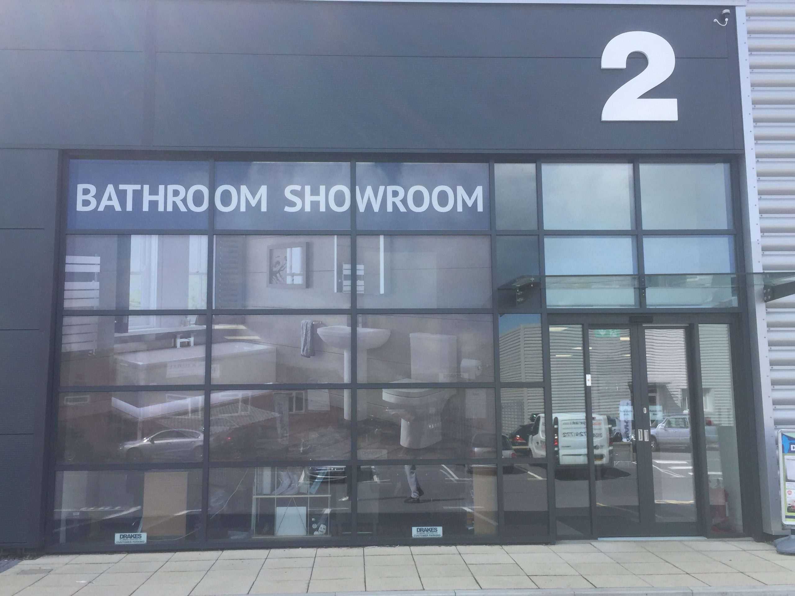 A photo of a bathroom show room with one way vision graphics