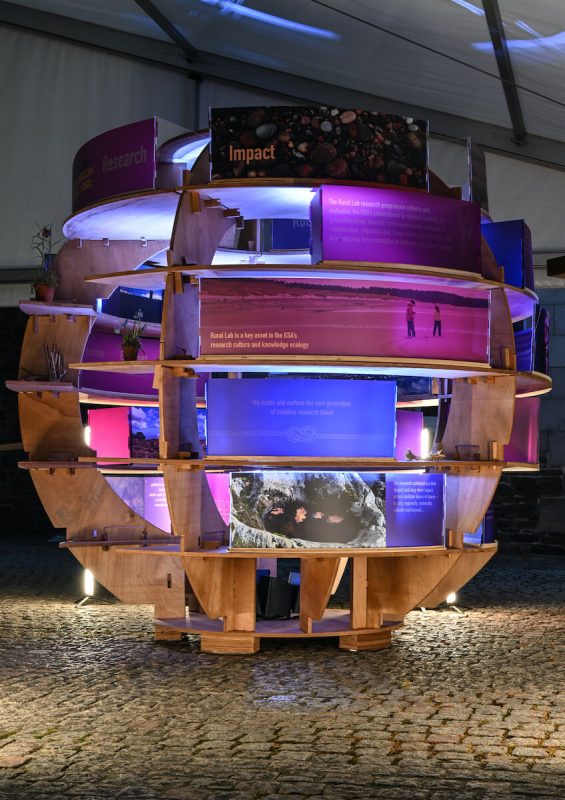 Night view of the Rural Lab installation glowing in purple and blue lighting at the Glasgow School of Art.