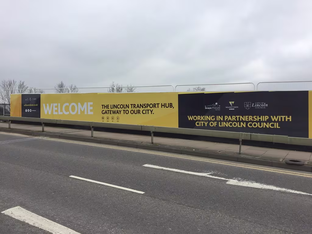 Printed hoarding panels being installed at a construction site in London