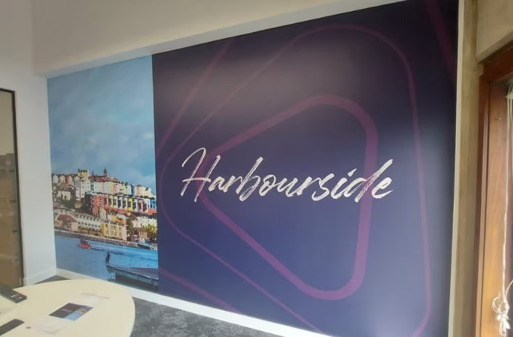 Printed wall graphics applied to an office meeting room wall with Harbourside branding