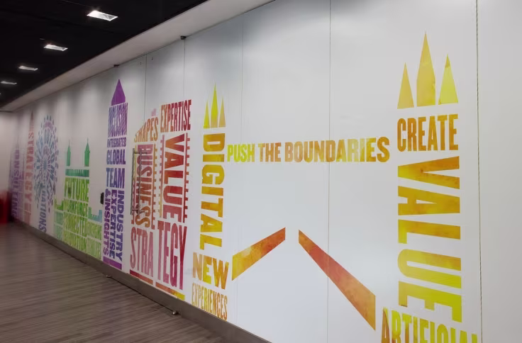 Printed wall vinyl with motivational text and branded typography in an office interior