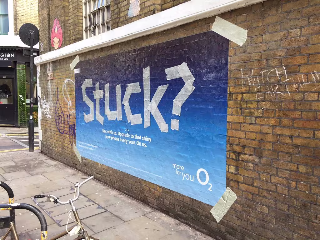 WW100 branded cut wall vinyl on a brick wall, view through a gated entrance