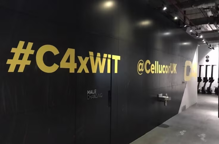 Cut wall vinyl with C4xWiT branding applied to a dark commercial interior wall
