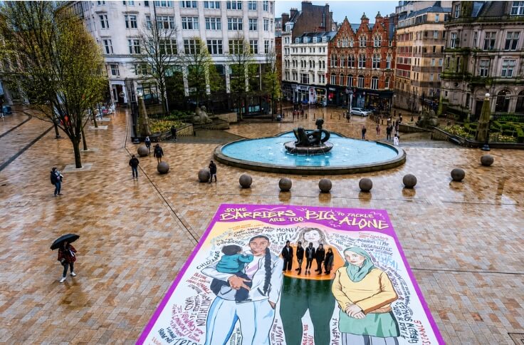 We Are Trade Printers 5 Large illustrated outdoor floor graphic installed across a public square beside a fountain.